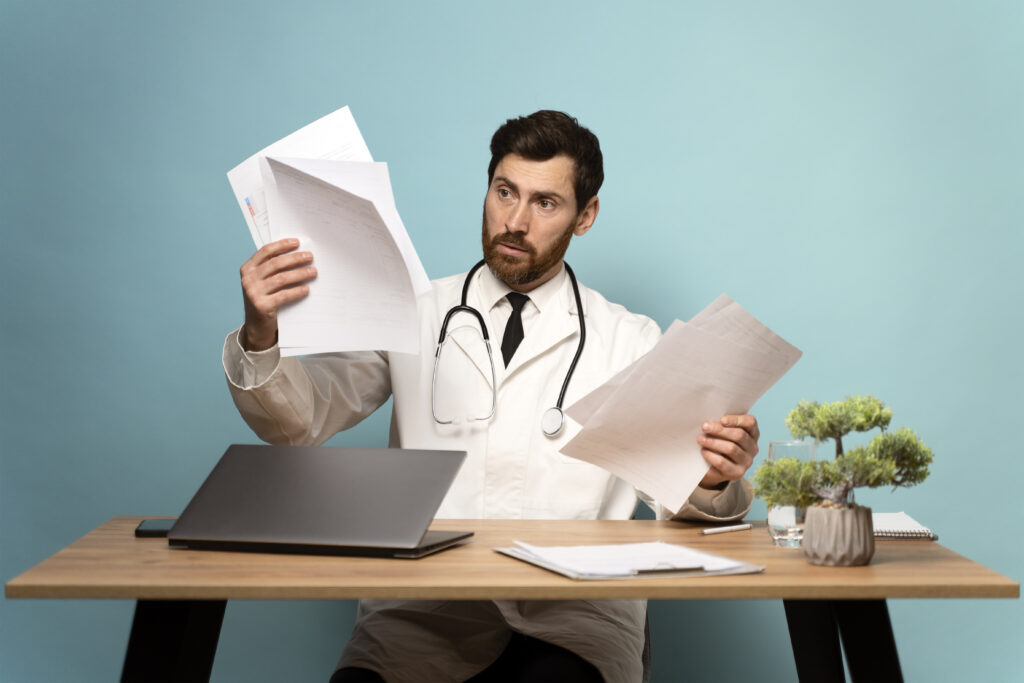 A healthcare provider reviews AHCCCS medical billing documents for Arizona Medicaid program patients.